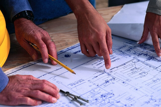 hands review an architectural drawing